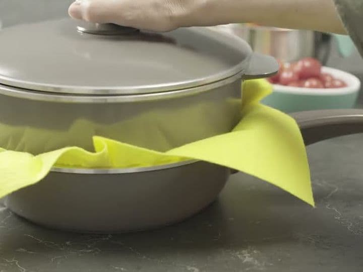 Una olla Essen guardada sobre otra con un paño amarillo en el medio